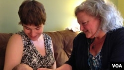 Certified Nurse Midwife Mairi Breen Rothman checks baby Debra as her mother, Beth Drake, looks on. September 25, 2014, VOA, J.Taboh