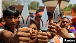 FILE - Supporters of hardline Vishwa Hindu Parishad [VHP] Hindu group hold tridents in the western Indian city of Ahmedabad, India, March 2013.