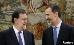 Spain's Prime Minister Mariano Rajoy (L) talks to King Felipe after taking his oath during a ceremony at Zarzuela Palace in Madrid, Spain, Oct. 31, 2016.