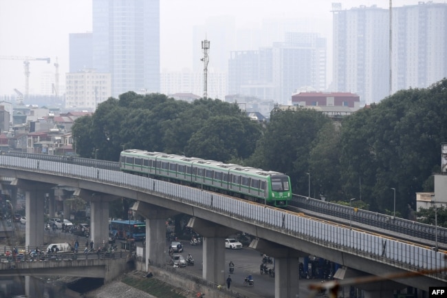 Cat Linh Ha Dong urban metro train Hanoi wide shot Description: Hanoi city's first urban metro train runs along the Cat Linh-Ha Dong line in Hanoi on December 12, 2020 on the first day of safety evaluation test runs. (Photo by Nhac NGUYEN / AFP)