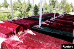 FILE - Coffins containing the bodies of Afghan national Army (ANA) soldiers killed in April 21's attack on an army headquarters are lined up in Mazar-i-Sharif, northern Afghanistan, April 22, 2017.
