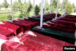 FILE - Coffins containing the bodies of Afghan national Army (ANA) soldiers killed in April 21's attack on an army headquarters are lined up in Mazar-i-Sharif, northern Afghanistan, April 22, 2017.