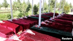 FILE - Coffins containing the bodies of Afghan national army soldiers killed in an April 21 attack on a military base in Mazar-i-Sharif, northern Afghanistan, April 22, 2017. 