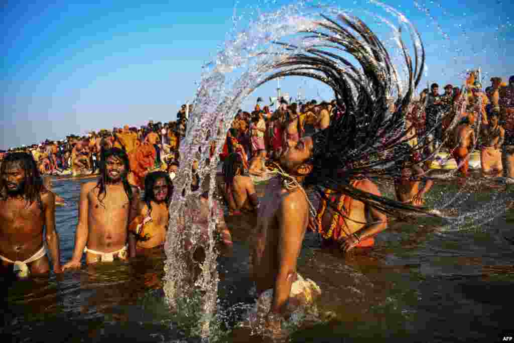 Indian sadhus (Hindu holy men) take a dip into the water of the holy Sangam — the confluence of the Ganges, Yamuna and mythical Saraswati rivers — during the auspicious bathing day of Makar Sankranti at the Kumbh Mela in Allahabad.
