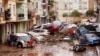 Residents look at cars piled up after being swept away by floods in Valencia, Spain, Oct. 30, 2024.