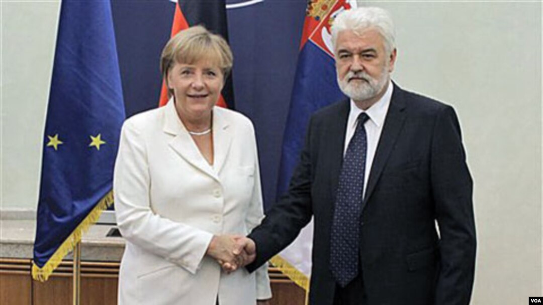 Kanselir Jerman Angela Merkel (kiri) berjabat tangan dengan PM Serbia Mirko Cvetkovic saat berkunjung ke Belgrade, Serbia (23/8).