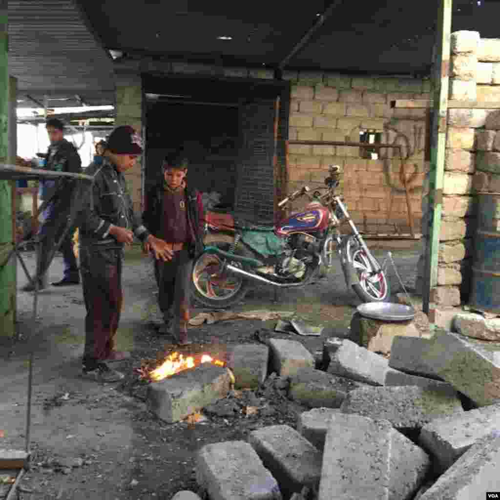 Anak-anak laki-laki di sebuah pasar di kota Qayyarah, sebelah selatan Mosul, Desember 2016. (VOA/Kawa Omar)