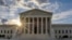 The sun flares in the camera lens as it rises behind the U.S. Supreme Court building in Washington, June 25, 2017.