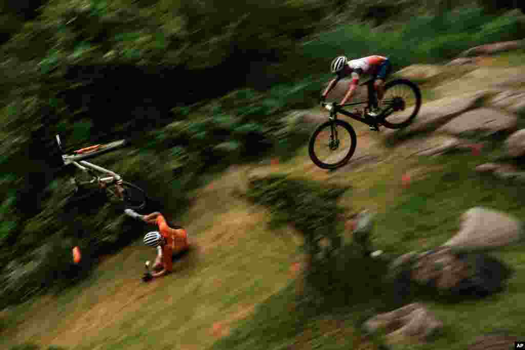 Mathieu van der Poel of the Netherlands tumbles on a downhill during the men's cross country mountain bike competition at the 2020 Summer Olympics in Izu, Japan.