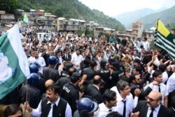 Pakistani police officers try to stop protesters from reaching the Line of Control between Pakistan and Indian Kashmir, at the border town of Chakoti, in Pakistani Kashmir, Aug. 29, 2019.