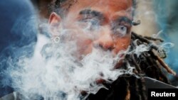 FILE - A demonstrator vapes during a protest at the Massachusetts State House against the state's four-month ban of all vaping product sales in Boston, Massachusetts, Oct. 3, 2019.