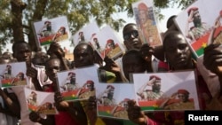 Des Burkinabès tiennent des photos de l'ancien président Thomas Sankara et du premier ministre Isaac Zida à Ouagadougou, le 2 décembre 2014.