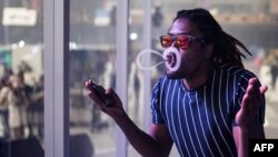 Seorang pria meniup asam dari rokok elektrik dalam kompetisi vaping, VapeCon, di Pretoria, Afrika Selatan, 1 September 2019. (Foto: AFP)