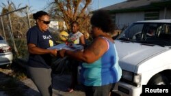 A volunteer of the NGO World Central Kitchen delivers food to Hurricane Dorian victims in the Abaco Islands, in Spring City, Bahamas, Sept. 10, 2019. 