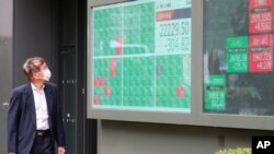 A man looks at an electronic stock board of a securities firm in Tokyo, June 25, 2020. 