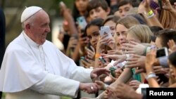 Pope Francis greets schoolchildren upon departing the Vatican Embassy in Washington. In the midst of his six-day trip, he moves on to New York for more outreach, Sept. 24, 2015.