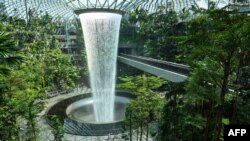 People walk around the rain vortex at Jewel Changi Airport in Singapore.
