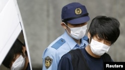 ARCHIVES - Tetsuya Yamagami, soupçonné d'avoir tué l'ancien Premier ministre japonais Shinzo Abe, est escorté par un officier de police à Nara, dans l'ouest du Japon, le 10 juillet 2022. (Photo: Kyodo)