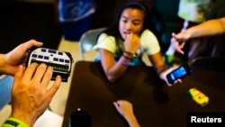 Technology is making communicating easier for people who cannot see or hear or both. Here, a child uses a Braille machine to type on his iPhone at Camp Abilities in Brockport, New York, June 25, 2013. 