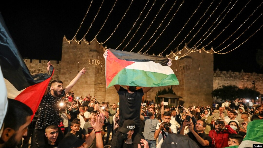 Palestinians celebrate outside Damascus Gate after barriers that were put up by Israeli police are removed, allowing them to access the main square that has been the focus of a week of clashes around Jerusalem's Old City, April 25, 2021.