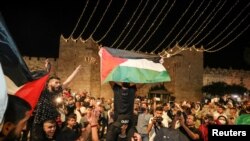 Palestinians celebrate outside Damascus Gate after barriers that were put up by Israeli police are removed, allowing them to access the main square that has been the focus of a week of clashes around Jerusalem's Old City, April 25, 2021.