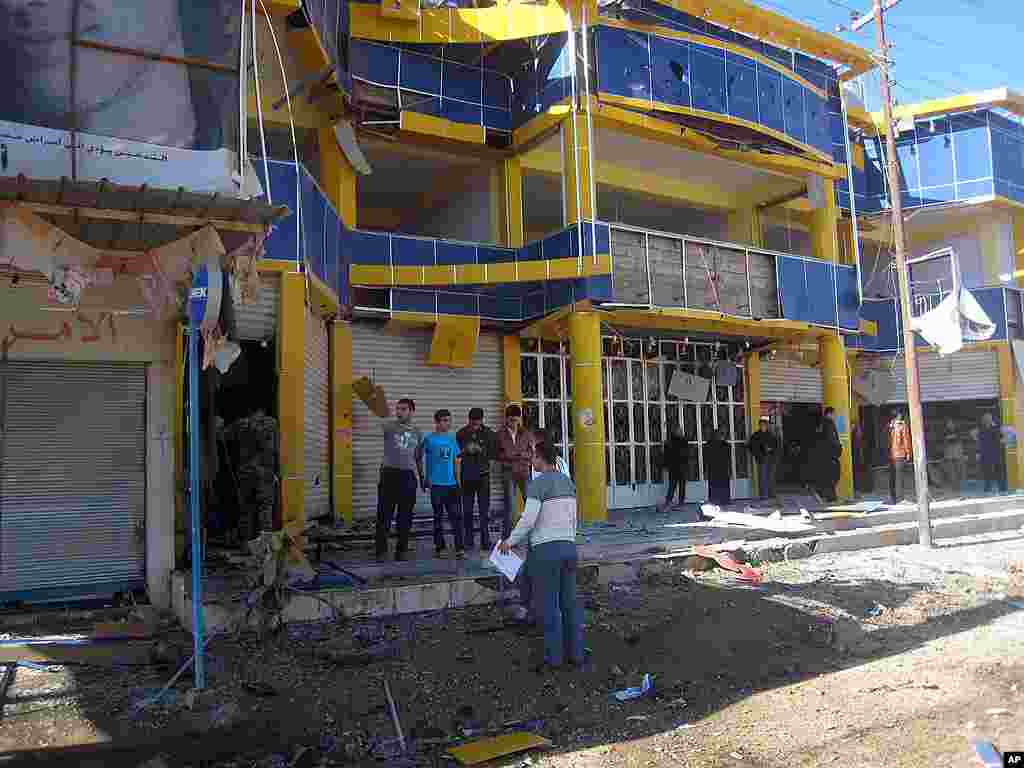 People inspect the scene of a car bomb attack in Kirkuk. (AP)