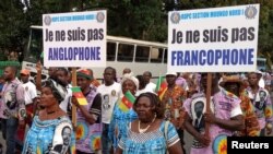 FILE - Demonstrators carry banners as they take part in a march voicing their opposition to independence or more autonomy for the anglophone regions, in Douala, Cameroon, Oct. 1, 2017.