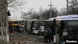 Buses wait along a road while travelling in the direction of the village of Debaltseve, Feb. 6, 2015.