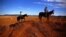 FILE - Farmer Scott Cooper and his daughter Charlie ride their horses along a fence in a drought-affected paddock on their property named "Nundah," south of the central New South Wales town of Gunnedah in Australia, July 21, 2018.