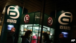 FILE - People walk past a fan shop of Bulgarian TV channel bTV in the capital Sofia, Thursday, Feb. 18, 2010.