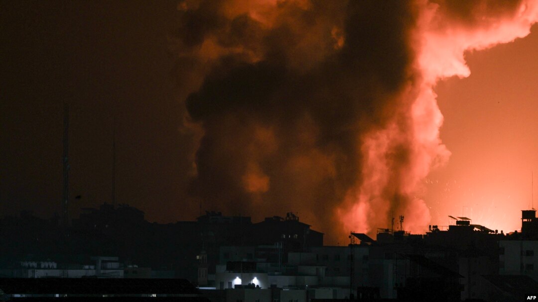 Asap dan api membubung dari sebuah gedung yang terkena serangan udara Israel di Gaza City, Minggu, 8 Oktober 2023. (Foto: Mahmud Hams/AFP)
