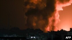 Asap dan api membubung dari sebuah gedung yang terkena serangan udara Israel di Gaza City, Minggu, 8 Oktober 2023. (Foto: Mahmud Hams/AFP)
