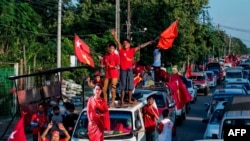 Supporters of the National League for Democracy (NLD) party celebrate with a cut-out figure of Myanmar state counsellor Aung San Suu Kyi in Yangon on November 10, 2020, as NLD officials said they were confident of a landslide victory in the weekend…