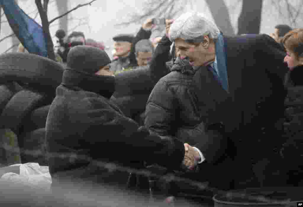 U.S. Secretary of State John Kerry shakes hands with a protester at the barricades in Kyiv, March, 4, 2014.