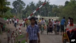 Muslim mendekati pos pemeriksaan keamanan di Maungdaw, negara bagian Rakhine utara, Myanmar.