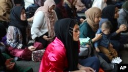 Amani Al-Khatahtbeh, center, sits at the Islamic Center of New York University during Friday prayers, Dec. 27, 2019. At 17, she and a group of friends started the blog Muslimgirl.com in response to anti-Muslim bullying they experienced after 9/11. 