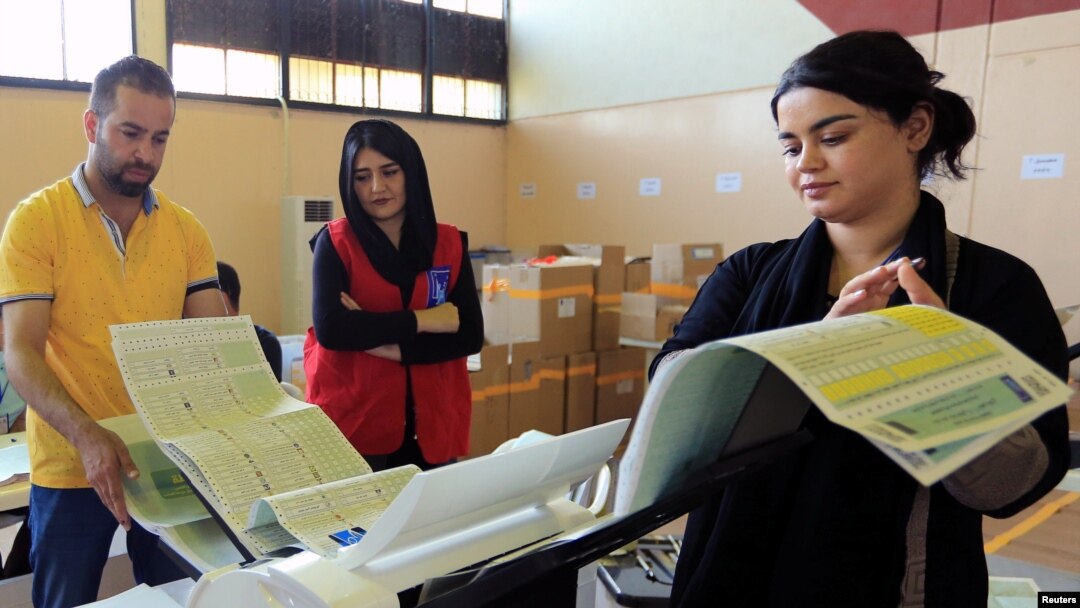Employees of the Iraqi Independent High Electoral Commission check an electronic counting device at a warehouse in Dohuk, Iraq, May 16, 2018. 