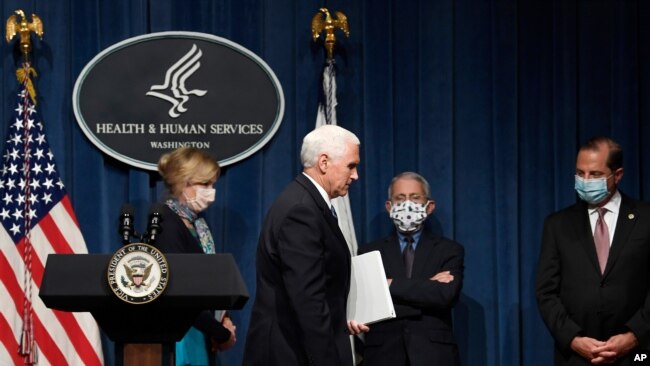 Vice President Mike Pence, second from left, walks off of the stage following the conclusion of a briefing with the Coronavirus Task Force at the Department of Health and Human Services in Washington, Friday, June 26, 2020. Dr. Deborah Birx, left,…