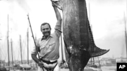 Ernest Hemingway posando con un marlin en el Havana Harbor, Florida, en julio de 1934. (Foto John F. Kennedy Presidential Library and Museum, Boston vía AP)