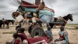 FILE - A Sudanese family who fled the conflict in Murnei in Sudan's Darfur region, sit beside their belongings while waiting to be registered by UNHCR upon crossing the border between Sudan and Chad in Adre, Chad, July 26, 2023.