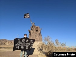 Alex Lee holds a flag after traveling on foot from West Covina to Barstow, California, in this undated photo. (Photo courtesy of Alex Lee)