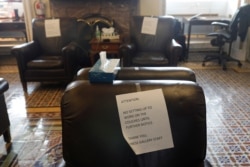 FILE - Signs calling for social distancing are posted on chairs used by journalists inside the U.S. Capitol on Capitol Hill in Washington, March 17, 2020.