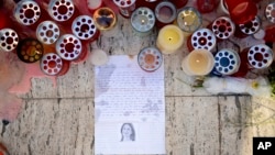 FILE - Candles, notes and paper cuttings lie next to the Love Monument in St. Julian, Malta, Oct. 17, 2017 the day after the killing of journalist Daphne Caruana Galizia.