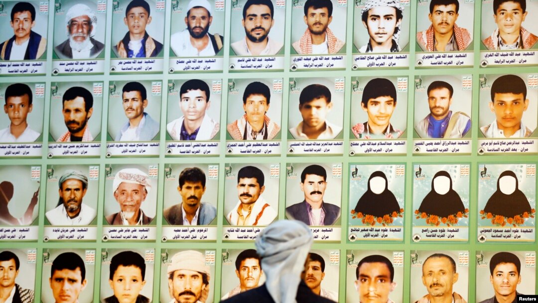 A man looks at photos of Houthi fighters killed during recent armed conflicts, at an exhibition commemorating them in Sana'a, March 5, 2015.