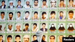 A man looks at photos of Houthi fighters killed during recent armed conflicts, at an exhibition commemorating them in Sana'a, March 5, 2015.