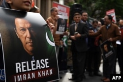 Seorang pendukung Imran Khan dari partai Pakistan Tehreek-e-Insaf (PTI) mengangkat plakat dalam demonstrasi di Sydney pada 4 Agustus 2024, menyerukan pembebasan mantan perdana menteri yang kini dipenjara tersebut. (Foto: AFP)