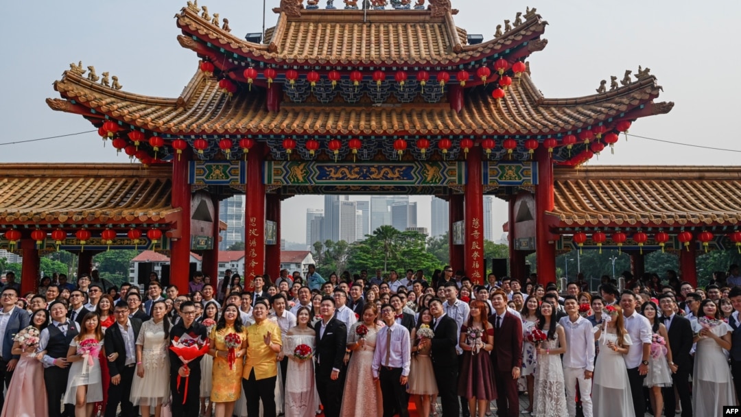 Puluhan pasangan pengantin baru Malaysia berfoto setelah upacara nikah massal yang digelar pada hari kesembilan, bulan kesembilan di kuil Thean Hou di Kuala Lumpur, Malaysia, 9 September 2019. (Foto: AFP)