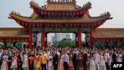 Puluhan pasangan pengantin baru Malaysia berfoto setelah upacara nikah massal yang digelar pada hari kesembilan, bulan kesembilan di kuil Thean Hou di Kuala Lumpur, Malaysia, 9 September 2019. (Foto: AFP)