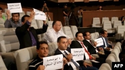 FILE - Yemeni journalists hold placards to support their colleagues jailed in Shi'ite Houthi rebel prisons in Yemen, during a press conference of the United Nations Special Envoy to Yemen in Kuwait City, May 5, 2016.