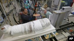 Argonne X-ray scientist Jonathan Almer, left, and Northwestern University Feinberg School of Medicine professor Stuart Stock, right, prepare to use high-energy X-ray beams to learn more about the 1,800-year-old mummified remains in Lemont, Ilinois, Nov. 27, 2017.